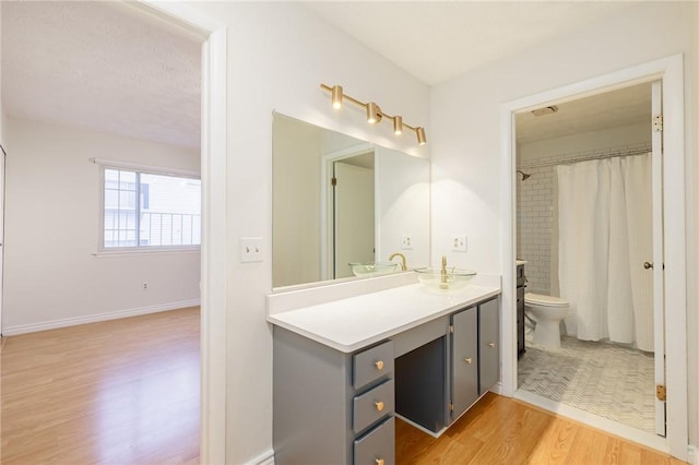 full bathroom featuring visible vents, toilet, vanity, wood finished floors, and baseboards