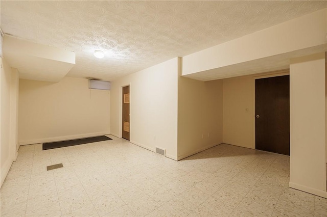 unfurnished room featuring visible vents, a textured ceiling, baseboards, and tile patterned floors