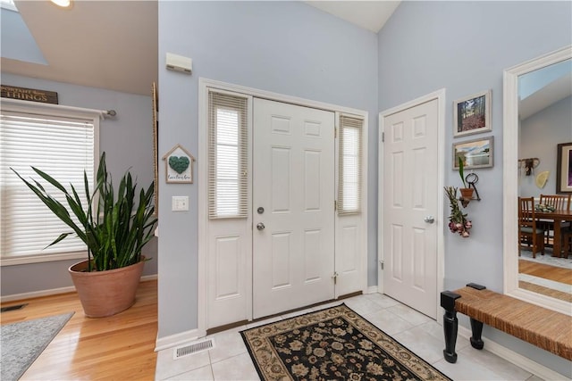 foyer entrance featuring visible vents, plenty of natural light, and light tile patterned flooring