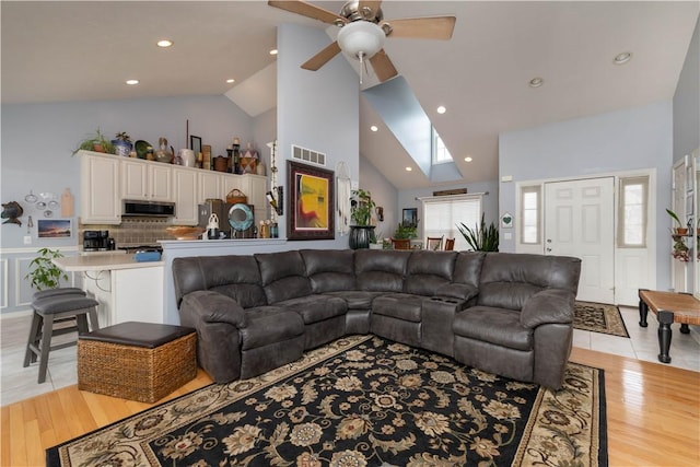 living area featuring light wood-type flooring, high vaulted ceiling, visible vents, and recessed lighting