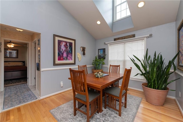 dining area featuring baseboards, high vaulted ceiling, wood finished floors, and a healthy amount of sunlight