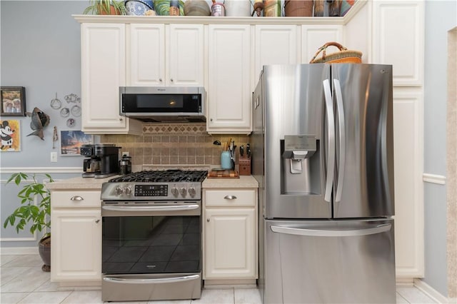 kitchen featuring light tile patterned floors, light countertops, appliances with stainless steel finishes, and backsplash