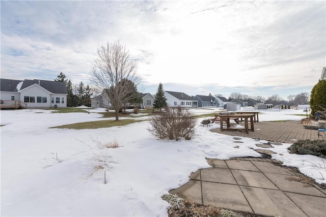 yard layered in snow with a residential view