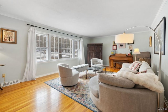 living room with ornamental molding, visible vents, baseboards, and wood finished floors