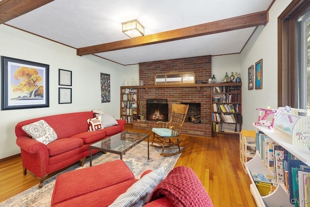 living area with a fireplace, beamed ceiling, and wood finished floors