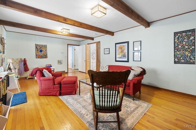 living area featuring light wood-type flooring, beam ceiling, and baseboards