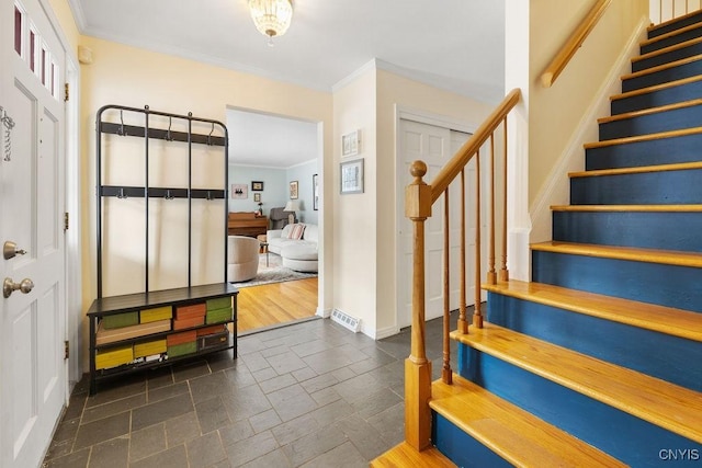 foyer with baseboards, stairs, ornamental molding, and stone tile flooring