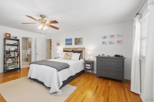 bedroom featuring a ceiling fan, light wood-style flooring, and ensuite bath