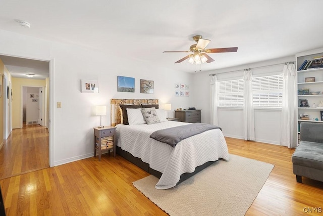 bedroom with baseboards, ceiling fan, and light wood finished floors