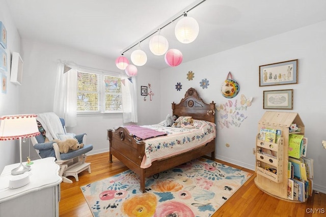 bedroom featuring baseboards and wood finished floors