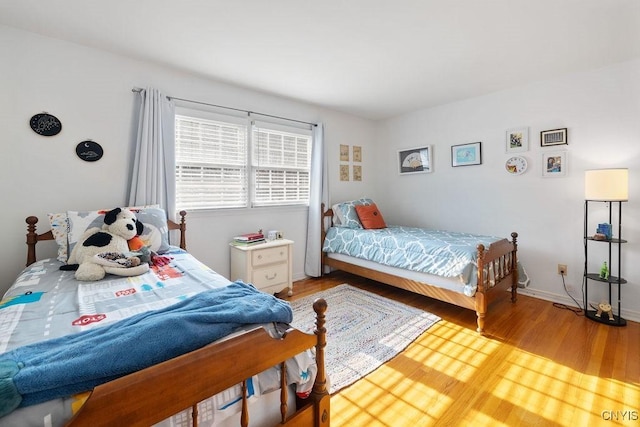 bedroom featuring baseboards and wood finished floors