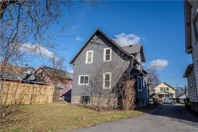 view of side of home featuring a yard and fence