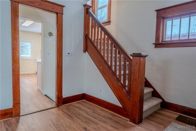 stairs with baseboards and wood finished floors