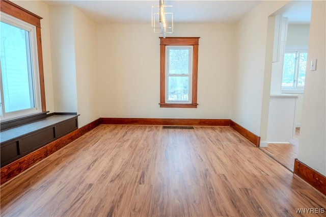 unfurnished room featuring visible vents, baseboards, and wood finished floors