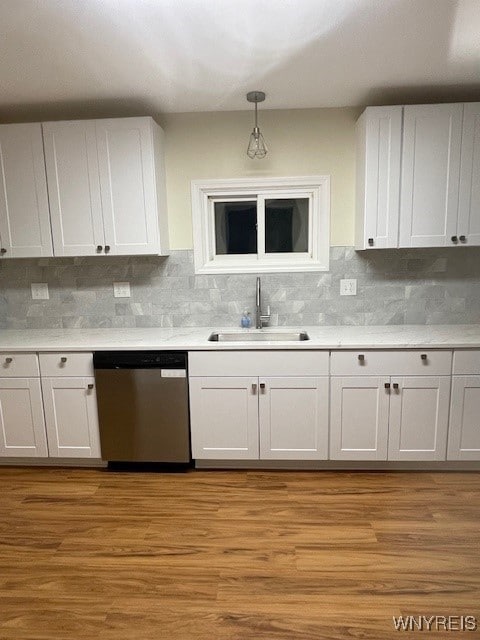 kitchen with light countertops, dishwasher, light wood-style flooring, and a sink