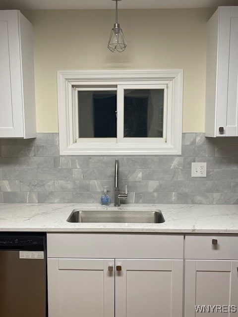 kitchen with stainless steel dishwasher, a sink, white cabinetry, and decorative backsplash