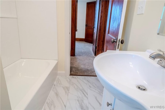 bathroom with marble finish floor, a sink, and baseboards