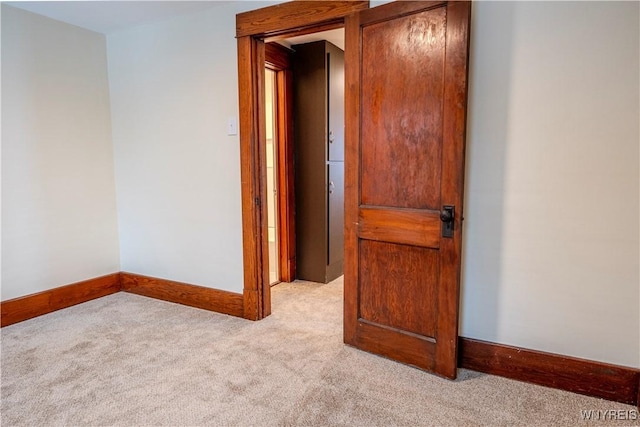 carpeted spare room featuring baseboards