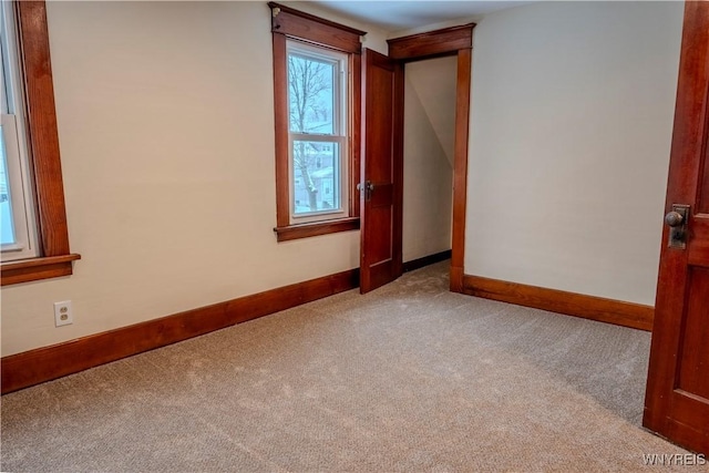 spare room featuring carpet floors and baseboards