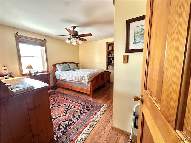 bedroom with a ceiling fan and wood finished floors