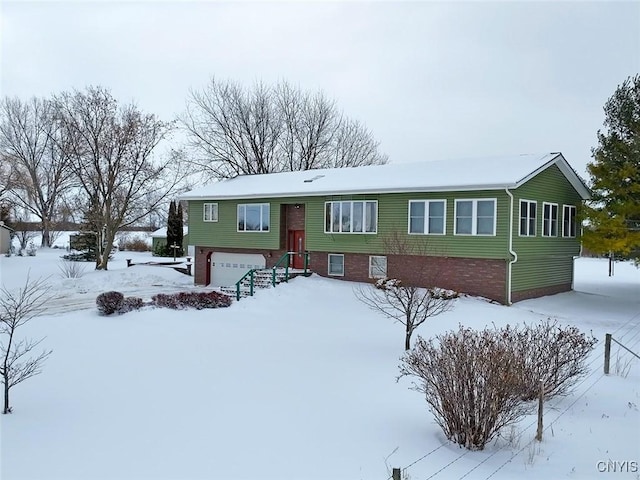 raised ranch featuring brick siding and an attached garage