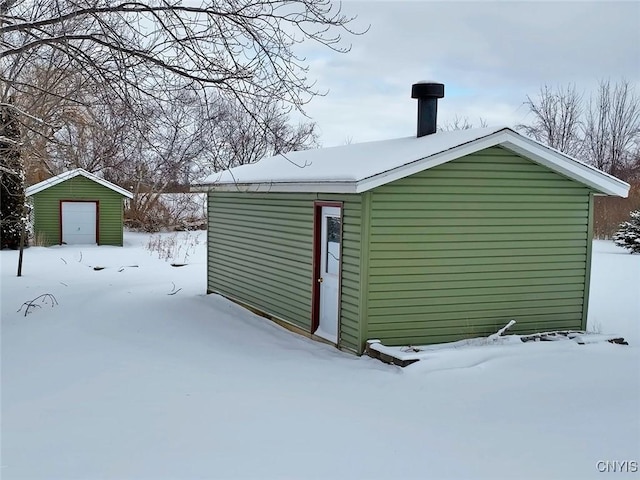 snow covered structure featuring an outdoor structure