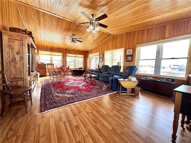 living room with lofted ceiling, wooden ceiling, wooden walls, and wood finished floors