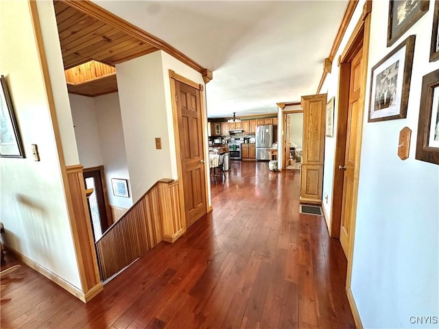 corridor with dark wood finished floors and an upstairs landing