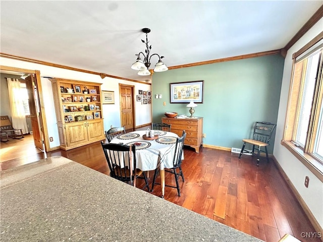 dining room featuring dark wood-style floors, a notable chandelier, plenty of natural light, and baseboards