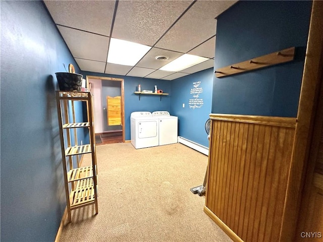 interior space with laundry area, baseboards, baseboard heating, carpet flooring, and washing machine and dryer