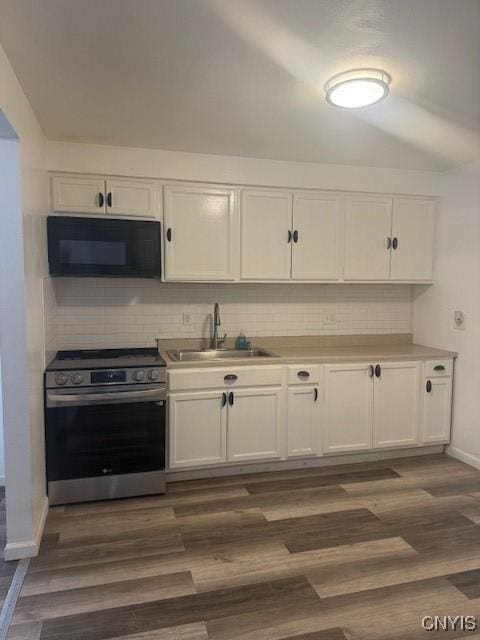 kitchen with dark wood-style floors, stainless steel electric stove, white cabinetry, a sink, and black microwave