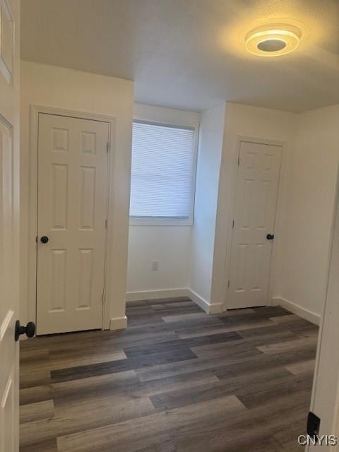 entryway with dark wood-style floors and baseboards