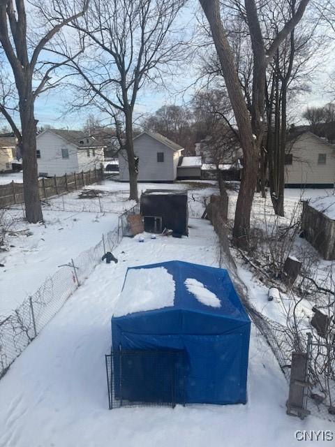 yard layered in snow with a garage and fence