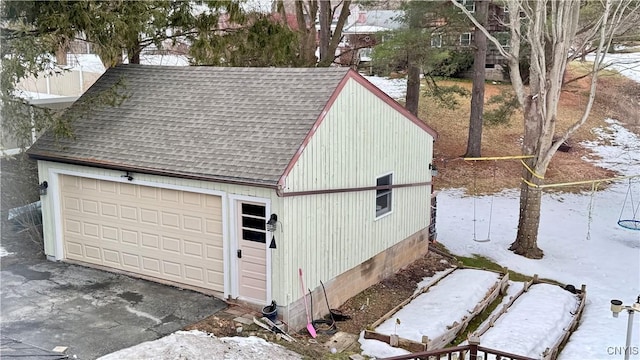 snow covered garage with a detached garage