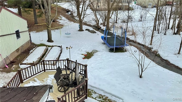 yard covered in snow featuring a trampoline