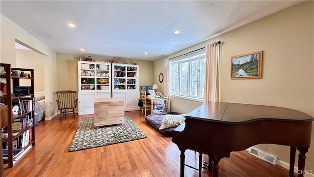 sitting room with baseboards, hardwood / wood-style flooring, visible vents, and recessed lighting