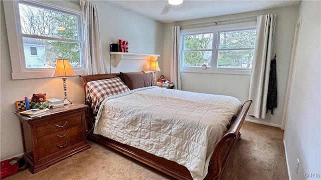 carpeted bedroom with ceiling fan and baseboards