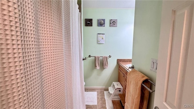 full bathroom featuring tile patterned flooring, vanity, and baseboards