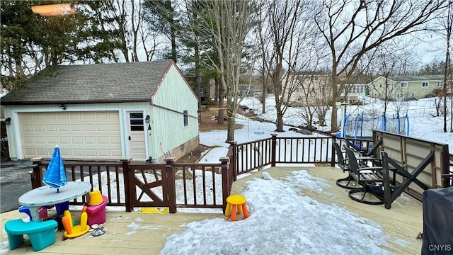 snow covered deck with a garage and an outdoor structure