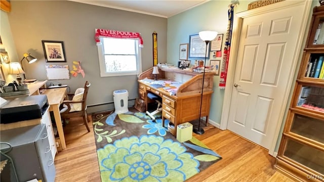 office space with a baseboard heating unit, crown molding, and light wood-style floors