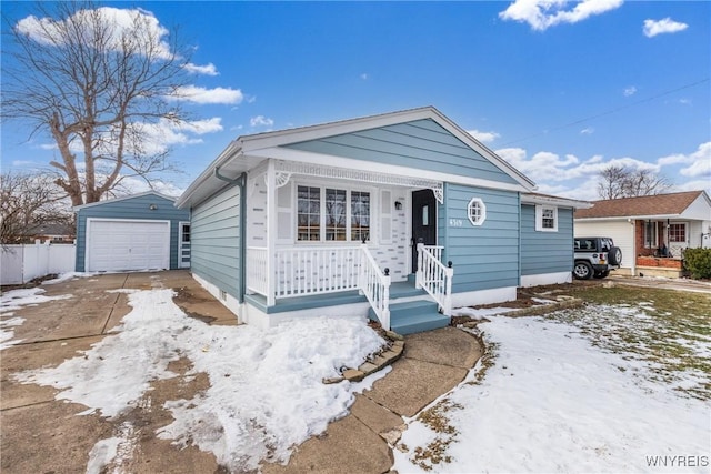 view of front of house with a garage, an outbuilding, a porch, and fence