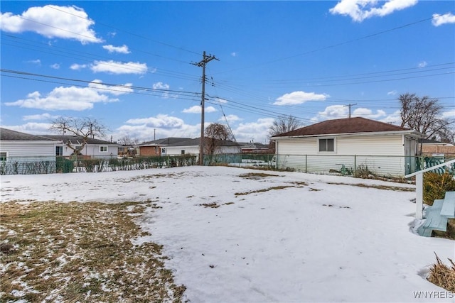 snowy yard featuring fence