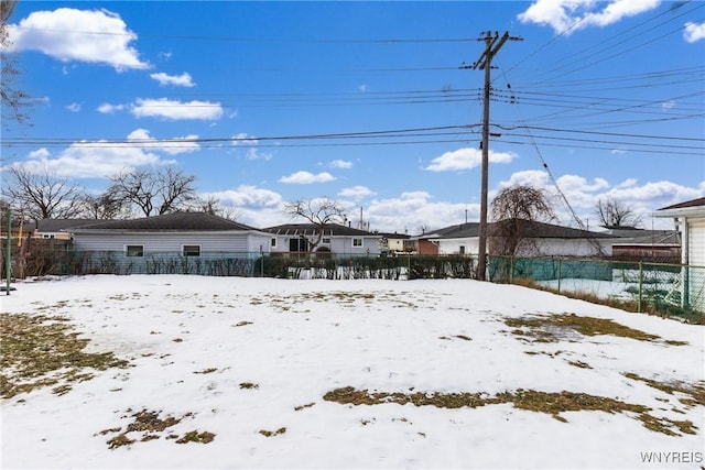 yard covered in snow featuring fence