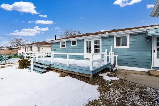 rear view of house featuring a wooden deck and french doors