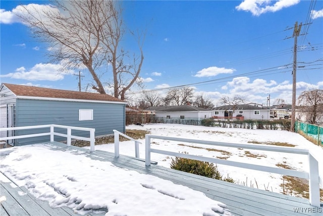 snowy yard with fence and an outbuilding