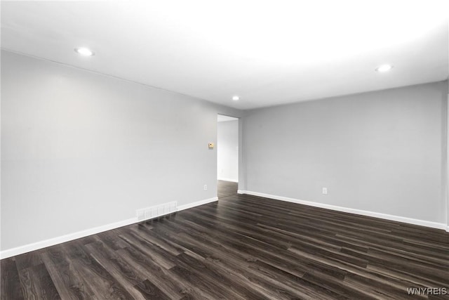 spare room with baseboards, visible vents, dark wood finished floors, and recessed lighting