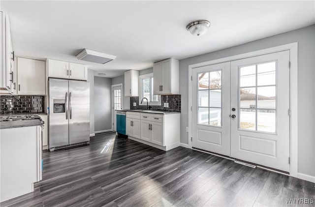 kitchen featuring dark wood-style floors, dishwashing machine, dark countertops, and stainless steel fridge with ice dispenser