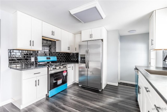 kitchen with dark wood-type flooring, white cabinetry, baseboards, appliances with stainless steel finishes, and tasteful backsplash