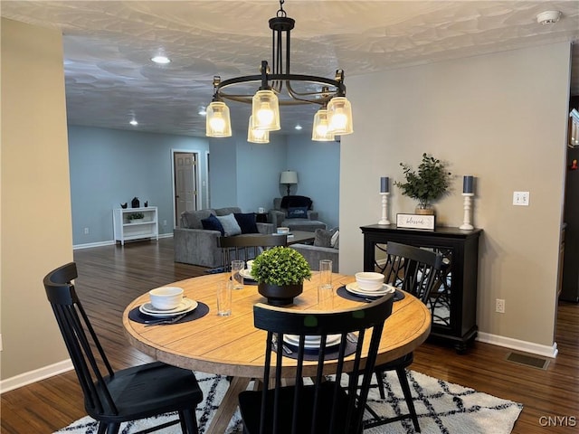 dining room featuring baseboards, visible vents, and wood finished floors