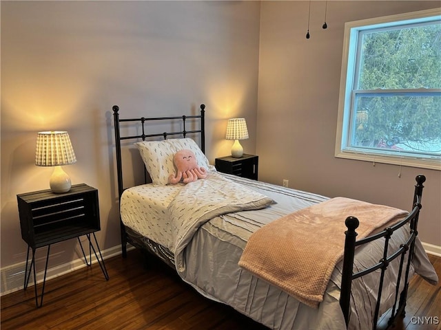 bedroom with baseboards and wood finished floors